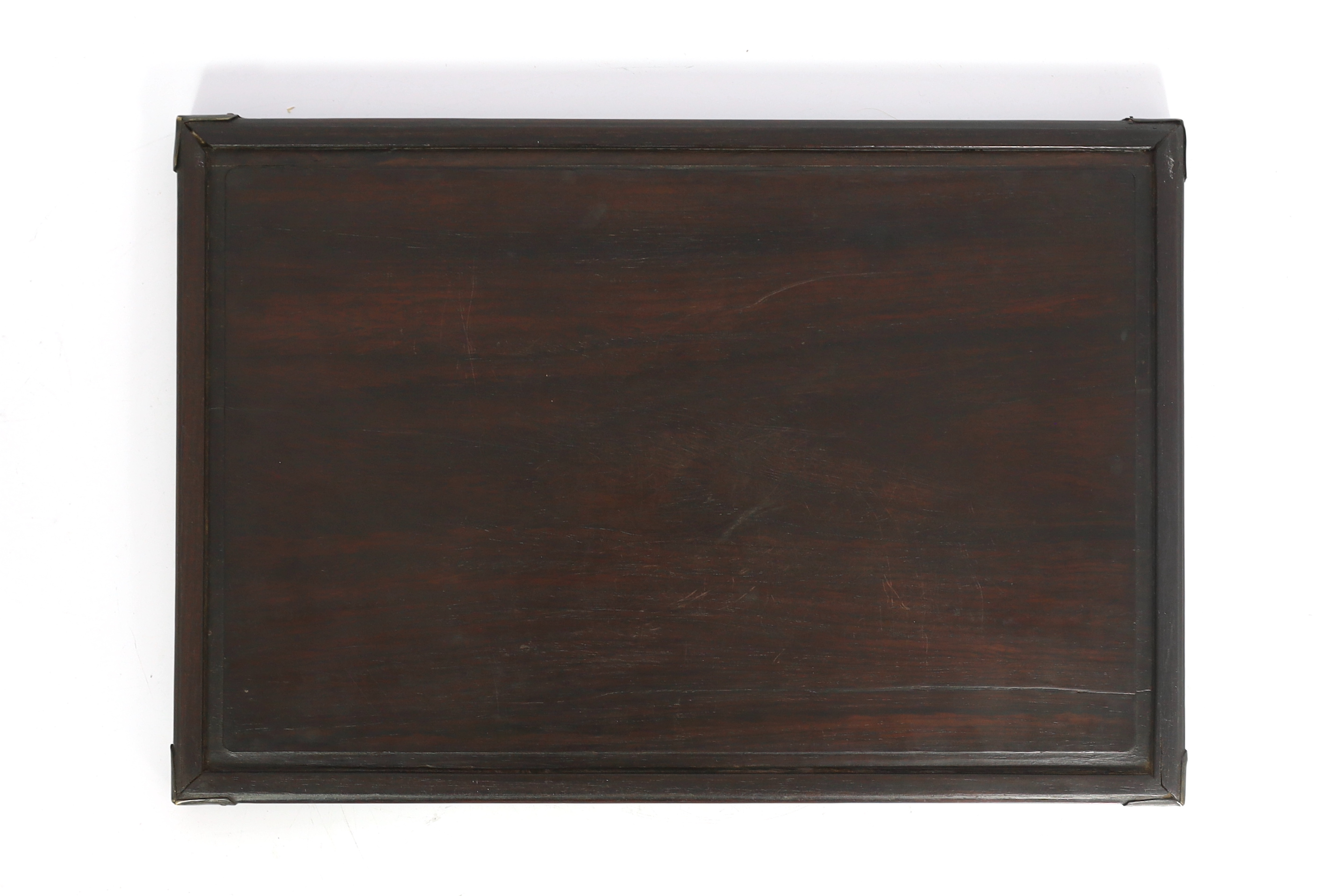 A Chinese hardwood rectangular tray, Qing dynasty, possibly Zitan, with brass mounted corners and reeded edges, 35.5cm x 23.5cm, old splits and repairs